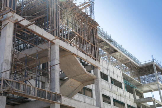 Chantier de construction ext&eacute;rieur avec structure en b&eacute;ton arm&eacute; en cours d'&eacute;dification