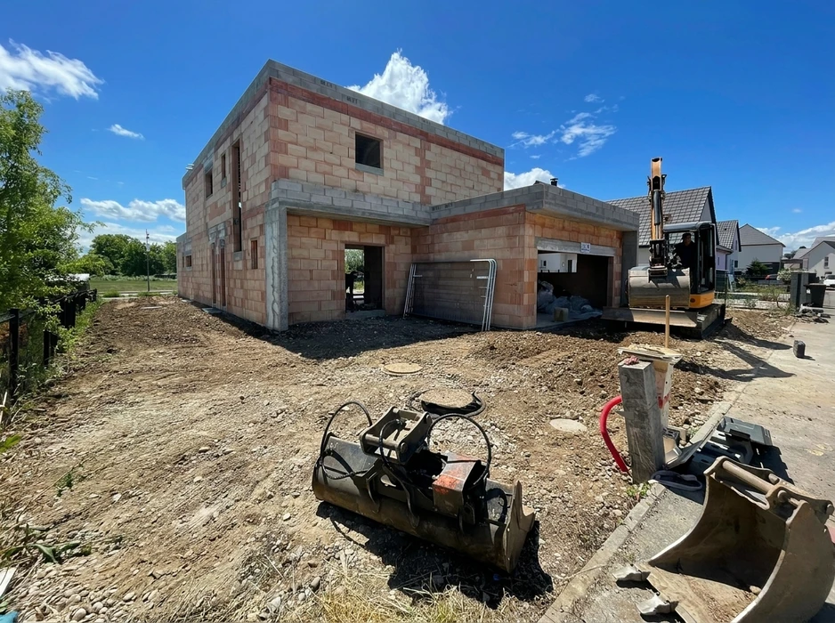 Chantier de construction d'une maison individuelle à ossature en blocs de béton cellulaire et briques monomur, au stade hors d'eau