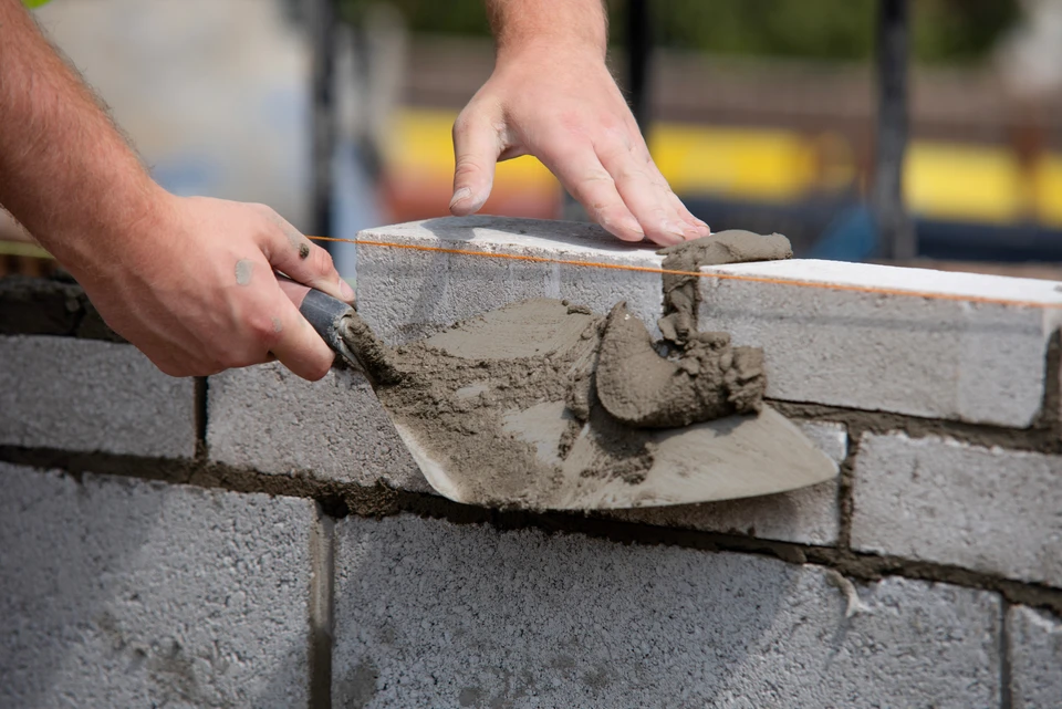 Chantier de construction en ext&eacute;rieur avec ouvriers en casques de s&eacute;curit&eacute; travaillant sur dalle b&eacute;ton arm&eacute;