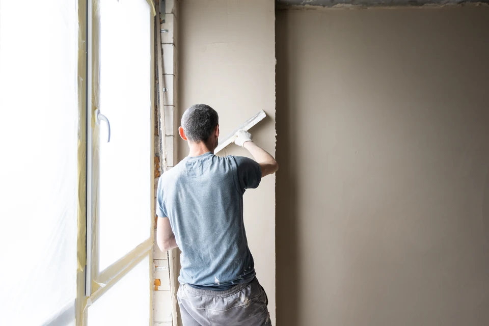Chantier de construction en extérieur avec ouvriers en gilets haute visibilité et casques jaunes travaillant sur une dalle en béton armé