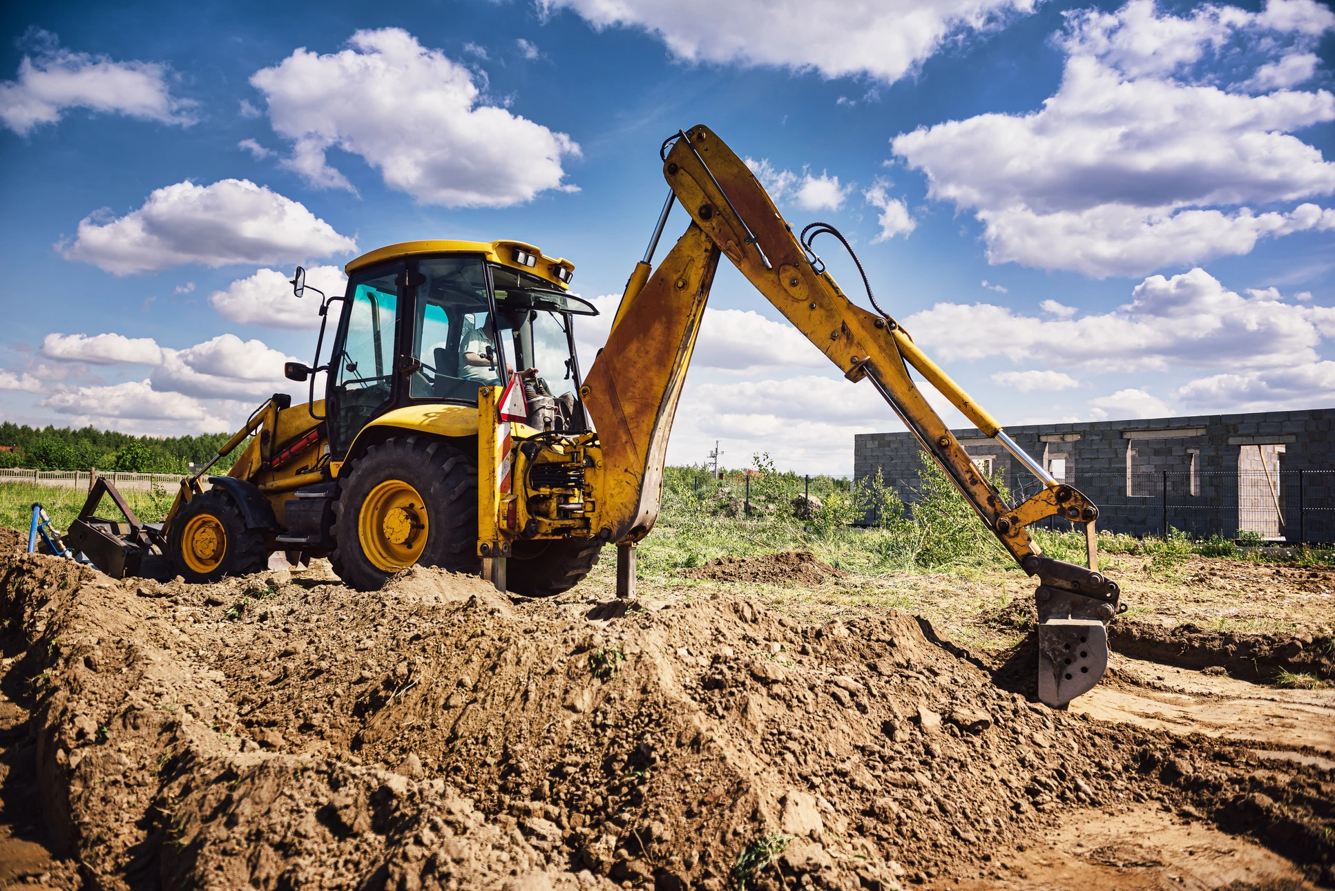 Chantier de construction extérieur avec pelleteuse hydraulique sur chenilles en activité